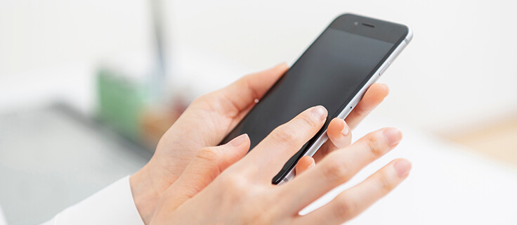スマートフォンを持つ女性の手